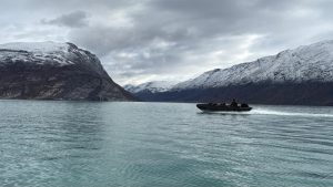 Nederlandse mariniers varen in een Landing Craft Rubber Motorized rubberboot door een weids en verlaten fjord in Groenland tijdens de NAVO-oefening Arctic Shield.