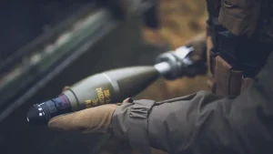 Een Nederlandse marinier houdt mortiergranaten vast tijdens een tactische training in de keten van sensor tot shooter.