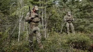 Twee mariniers bekijken bij een bosrand het scherm van hun nieuwe transferradio om de posities van hun eenheid te bepalen.